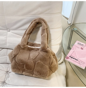 Close-up of brown faux fur tote bag featuring embossed heart pattern on soft fabric