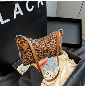 Detail of leopard print shoulder bag with brown leather strap and zipper closure
