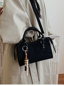 Sac bandoulière rétro noir avec pampille en perles et bandoulière porté par un mannequin
