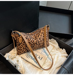 Detailed view of leopard print shoulder bag in gift box with brown leather strap and zipper