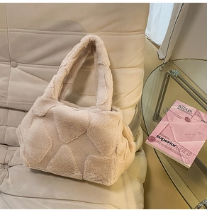 Detailed close-up of beige plush tote bag with quilted texture on a stylish sofa