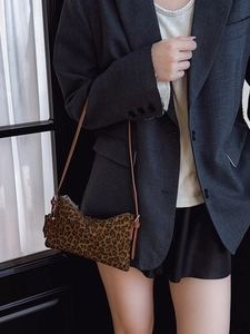 Stylish leopard print crossbody bag worn by a model with a dark blazer for a trendy look