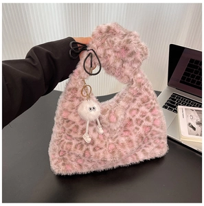 Detail of pink leopard faux fur tote bag with a cute white plush pendant and top handle
