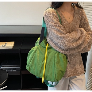 Close-up of emerald green nylon tote bag with contrasting yellow drawstring detail