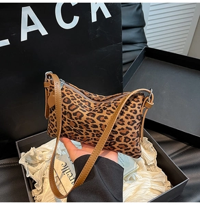 Detail of leopard print tote with silver zipper and brown leather shoulder strap