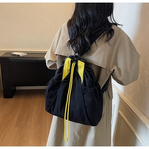 Detail of black drawstring backpack with bright yellow accents and high-density fabric