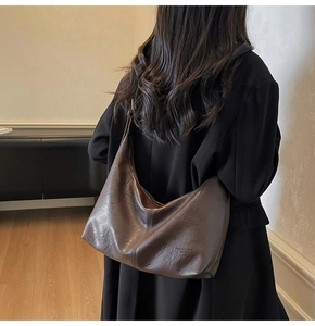 Detail of vintage dark brown faux leather tote bag showing soft texture and crescent shape