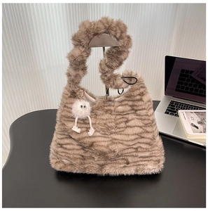 Detail of plush brown wavy faux fur shoulder bag with cute monster keychain charm