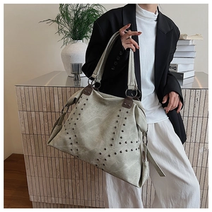Detail of vintage tote bag with silver studs, distressed texture and double handles