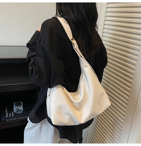 Detail view of a soft cream leather hobo bag showing natural texture and supple drape