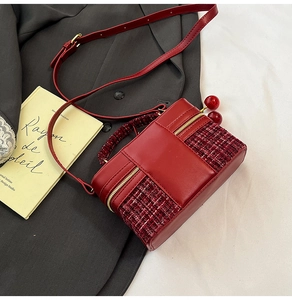 Detail of red tweed and faux leather crossbody bag with cute cherry pendant charms