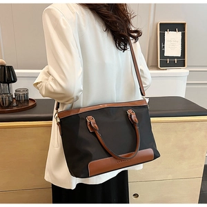 Vue arrière du mannequin portant un sac fourre-tout en nylon noir avec poignées en cuir