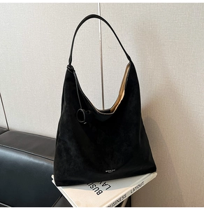 Close-up of black suede hobo tote bag featuring a large capacity and branded logo detail