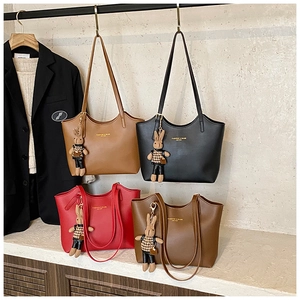 Détail de sacs fourre-tout élégants en quatre couleurs avec breloques de lapin et cuir chic