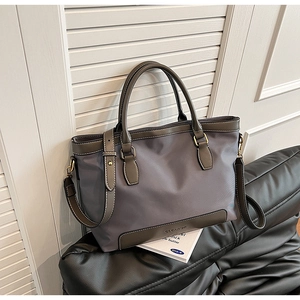 Détail du sac fourre-tout en nylon gris-violet avec bordure en cuir et bandoulière réglable