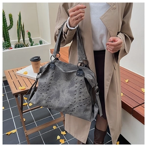 Detail of grey studded tote bag with silver star pattern and large capacity capacity