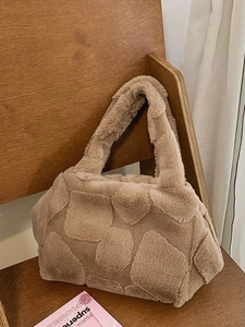 Plush khaki faux fur tote bag with geometric texture on a vintage wooden chair