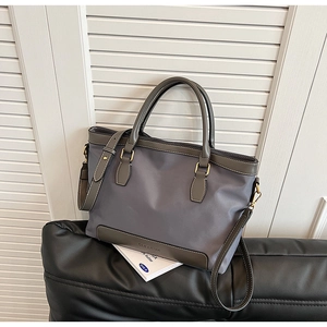 Détail du sac cabas en nylon gris montrant le logo et les ferrures dorées