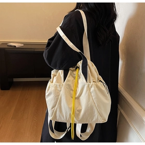 Detail of multi-functional cream canvas tote showing drawstring and shoulder straps