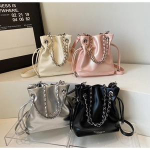 Detail of multi-color drawstring bucket bags with chain handles and adjustable straps