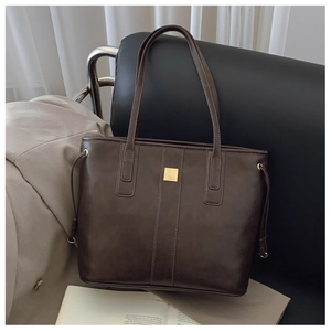 Detail view of deep coffee tote bag with matte finish and gold square metal hardware