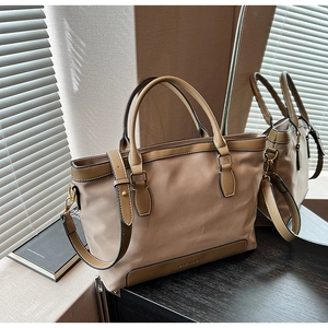 Détails d'un sac cabas kaki avec poignées en cuir marron et bandoulière réglable