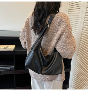 Detail view of black vintage hobo bag with adjustable metal buckle on shoulder strap