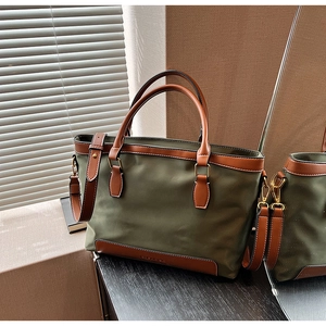 Détail du cabas en nylon vert olive avec poignées en cuir marron et détails dorés