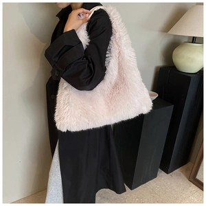 Fuzzy pink faux fur tote bag worn with a black coat for a stylish winter street look