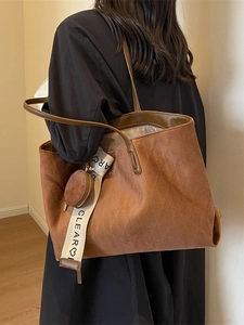 Vintage brown tote bag with diamond pattern and a small round coin purse charm