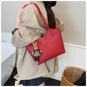 Détail du sac cabas en cuir rouge avec lettrage doré et pendentif lapin mignon