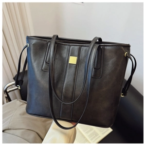 Detail shot of the dark coffee leather tote bag with elegant gold buckle and side drawstrings