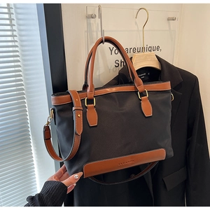 Détails du sac à main en nylon noir et marron avec finitions en cuir et boucles d'or
