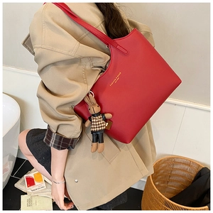 Détail du cabas en cuir rouge avec lettrage doré et breloque lapin en peluche marron