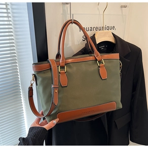 Détail du sac cabas en nylon vert olive avec anses en cuir marron et bandoulière réglable
