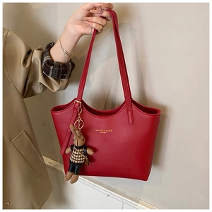 Détail d'un cabas en cuir rouge avec logo doré et pendentif lapin élégant de mode