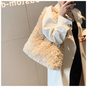 Close-up of fluffy light beige plush tote bag with soft faux fur texture and leather strap