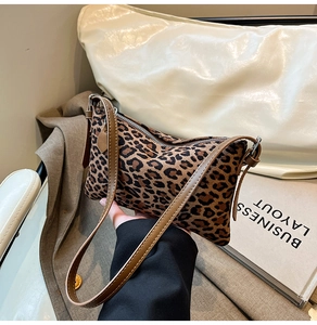 Detail of leopard print shoulder bag with brown leather strap and silver zipper closure