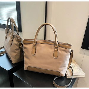 Détail d'un sac cabas en nylon kaki avec bordure en cuir marron et logo CLEAROK au miroir