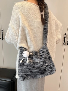 Faux fur animal print hobo bag with plush ball charm and wide shoulder strap