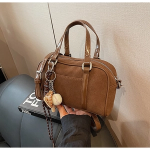Detailed texture of brown Boston bag with suede finish and leather handles