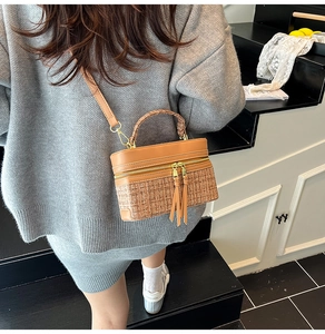 Detail of tweed and brown leather crossbody bag featuring stylish long leather tassels
