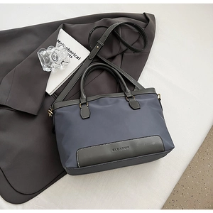 Détail du sac fourre-tout en nylon bleu gris avec contraste en cuir et bandoulière