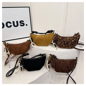 Detail of crescent crossbody bags in leopard print and suede with beaded charms
