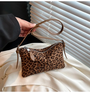 Close-up of leopard print handbag featuring suede texture and silver metal zipper detail