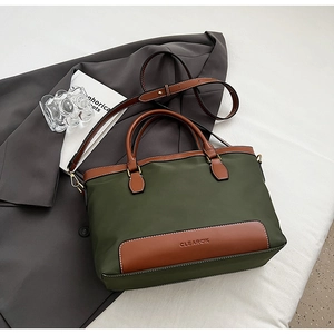 Détail du cabas en nylon olive avec finitions en cuir brun et bandoulière réglable