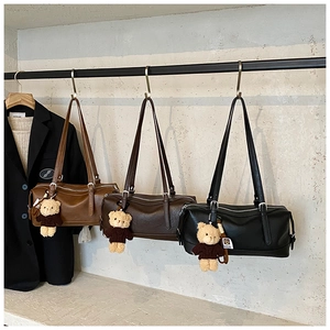 Detailed display of three vintage cylinder bags in brown and black with bear charms