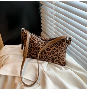 Detail of leopard print shoulder bag with brown leather strap and silver zipper closure
