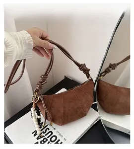 Detail of leopard print croissant bag with suede texture and wooden bead decoration