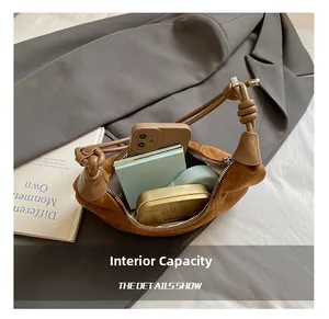 Détail de l'intérieur spacieux d'un sac en daim marron avec téléphone et maquillage